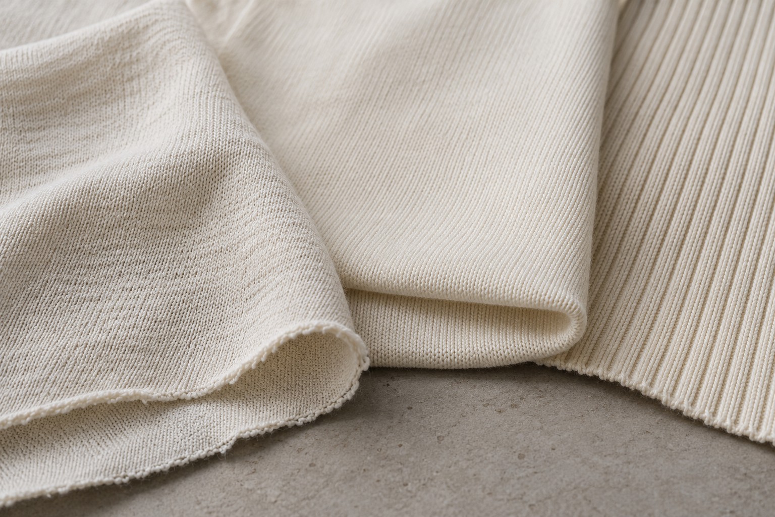 Three cream knit fabric swatches showing jersey, smooth interlock, and vertical rib textures.